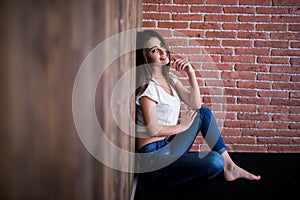 Girl sitting down against wooden