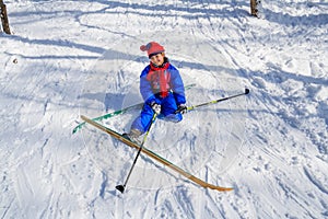 Girl sitting down on the snow learning skiing