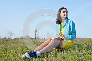 Girl sitting on the field in summer