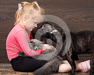Girl sitting on the floor with a kitten and a dog