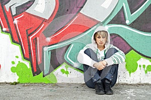 Girl sitting on the floor near graffiti wall