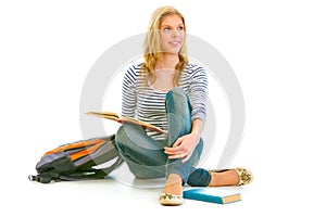 Girl sitting on floor with schoolbag and books