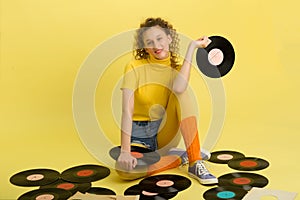 Girl sitting on floor surrounded by vinyl records
