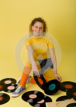 Girl sitting on floor surrounded by vinyl records