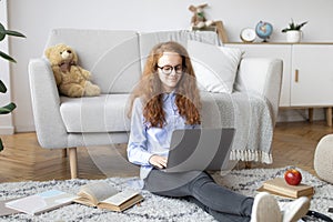 Girl sitting on the floor, using laptop, typing on keyboard