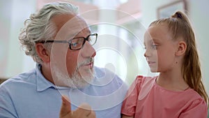 Girl sitting on grandfather laps. Grandparent teaching granddaughter to count