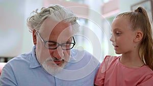 Girl sitting on grandfather laps. Grandparent teaching granddaughter to count