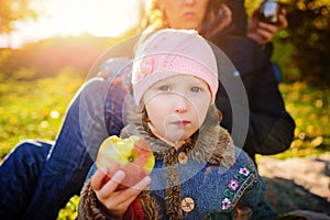 Girl sitting on the grass with an apple in his hand