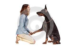 Girl sitting on her knees in front of a large black dog