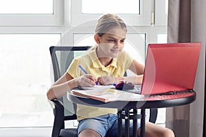 Girl sitting at home remotely watching a virtual lesson