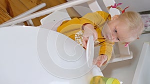 The girl is sitting at the kitchen table and indulging in food.