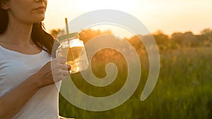 Girl sitting in a meadow with lemonade in her hands