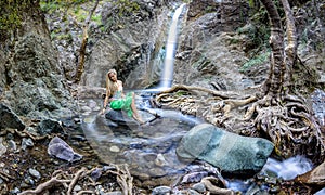 Girl sitting by the millomeri waterfalls in the troodos mountains photo