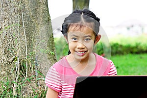 Girl sitting in park with a laptop