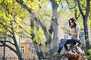 Girl sitting in the park and reading a map