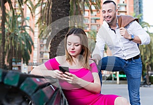 Girl is sitting with phone and inaccessibility for stranger man