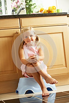 Girl Sitting On Plastic Step In Kitchen