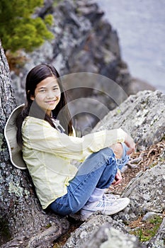 Girl sitting on rock cliff edge