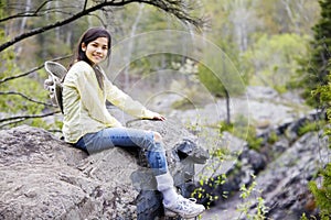 Girl sitting on rock cliff edge