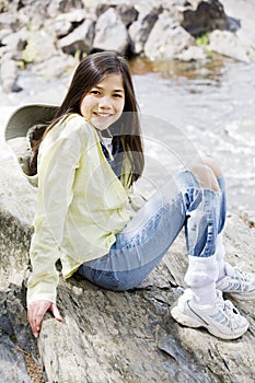 Girl sitting on rock cliff edge