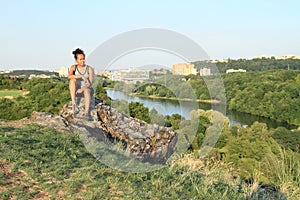 Girl sitting on rock in Divoka Sarka in Prague
