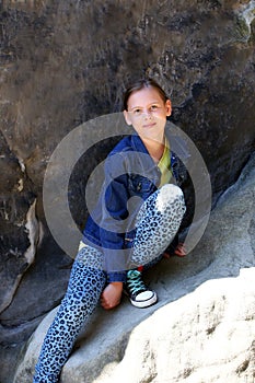 Girl sitting on a rock outdoors