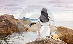 Girl sitting on the seaside rocks