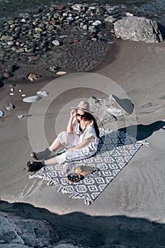 Girl sitting on the shore of a mountain river