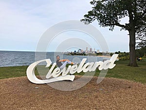 A girl sitting on the sign cleveland