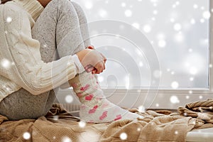 Girl sitting on sill at home window in winter