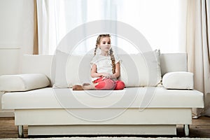 Girl sitting on sofa at home