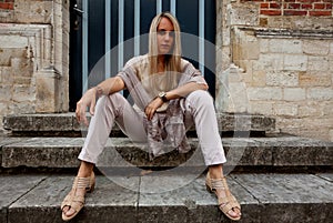 Girl sitting stairs medieval Romanesque door evening sun