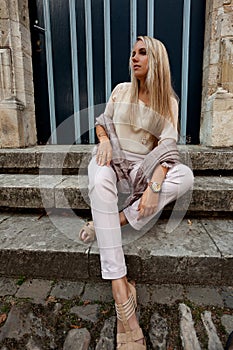 Girl sitting stairs medieval Romanesque door evening sun