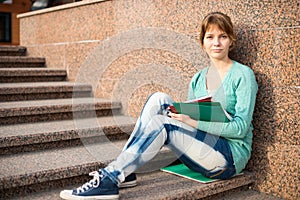 Girl sitting on stairs and reading note