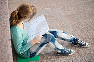 Girl sitting on stairs and reading note