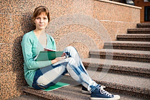 Girl sitting on stairs and reading note