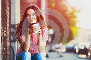 Girl sitting in street with coffee