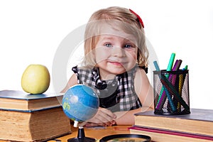 Girl sitting at table with books and globe