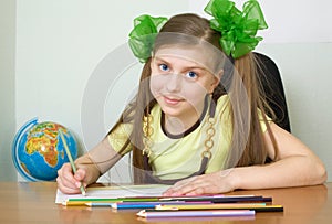 Girl sitting at a table with pencils