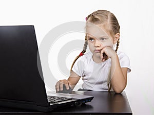 The girl sitting at the table and quietly working behind the notebook