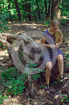 Girl sitting on a tree stump