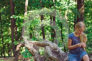 Girl sitting on a tree stump