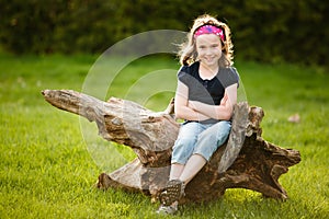 Girl sitting on a tree trunk