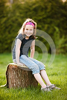 Girl sitting on a tree trunk