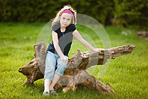 Girl sitting on a tree trunk