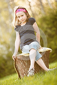 Girl sitting on a tree trunk