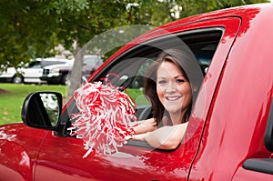 Girl Sitting in Truck with Pom Pom