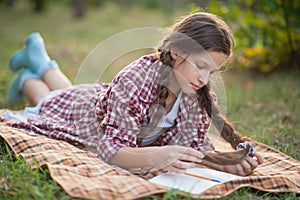 The girl sitting under the tree and wrote in Notepad
