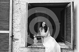 Girl sitting on the window with cat