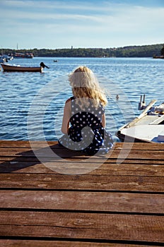 Girl sitting in wooden jetty